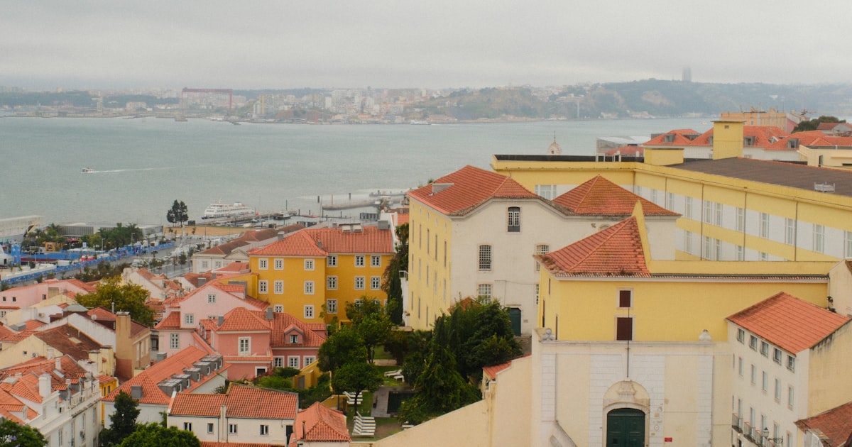Cityscape overlooking a wide river with buildings.