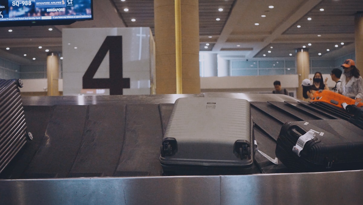 A passenger weighing their suitcase on a luggage scale at home before heading to the airport