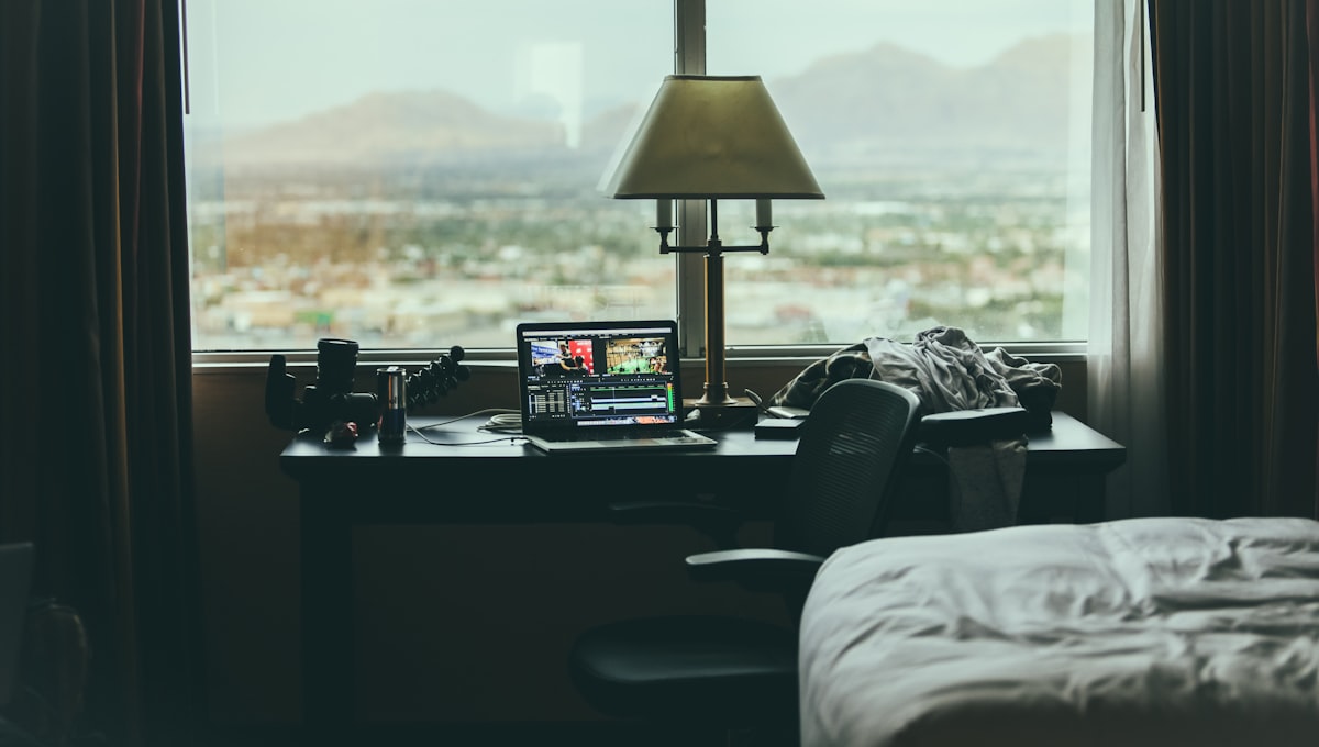 tabletop lamp beside laptop on desk beside window