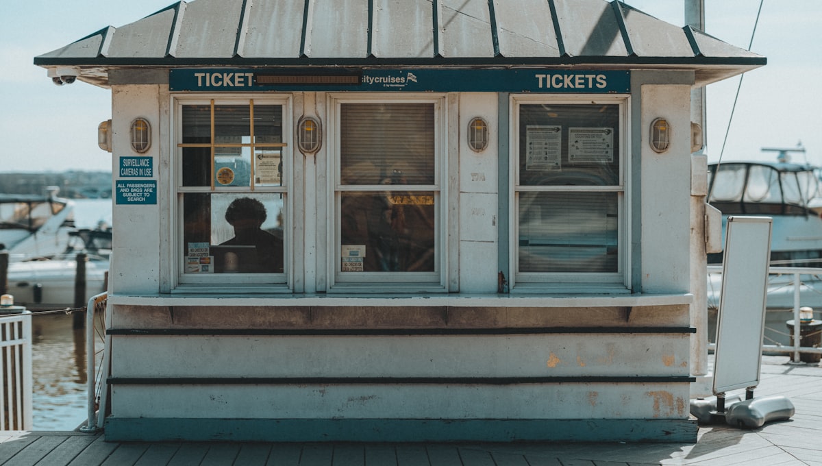 A small ticket booth with a person inside.