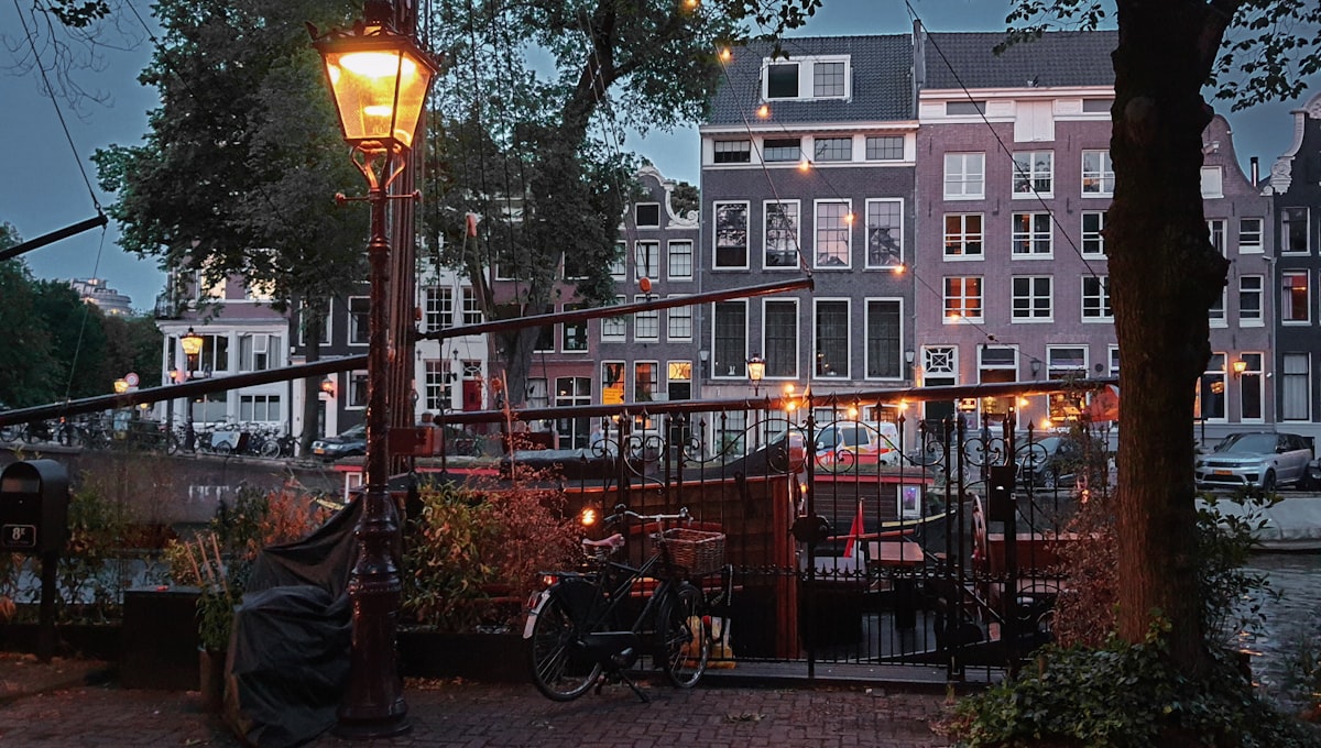 Narrow brick canal houses reflecting in the Herengracht canal on a grey morning