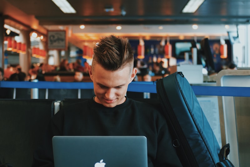 Traveler comparing flight prices on a laptop at an airport terminal